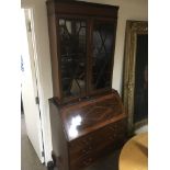 A Edwardian inlaid bureau with added bookcase top the fall front above two short and two long