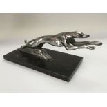 A vintage car mascot of a leaping greyhound, appro