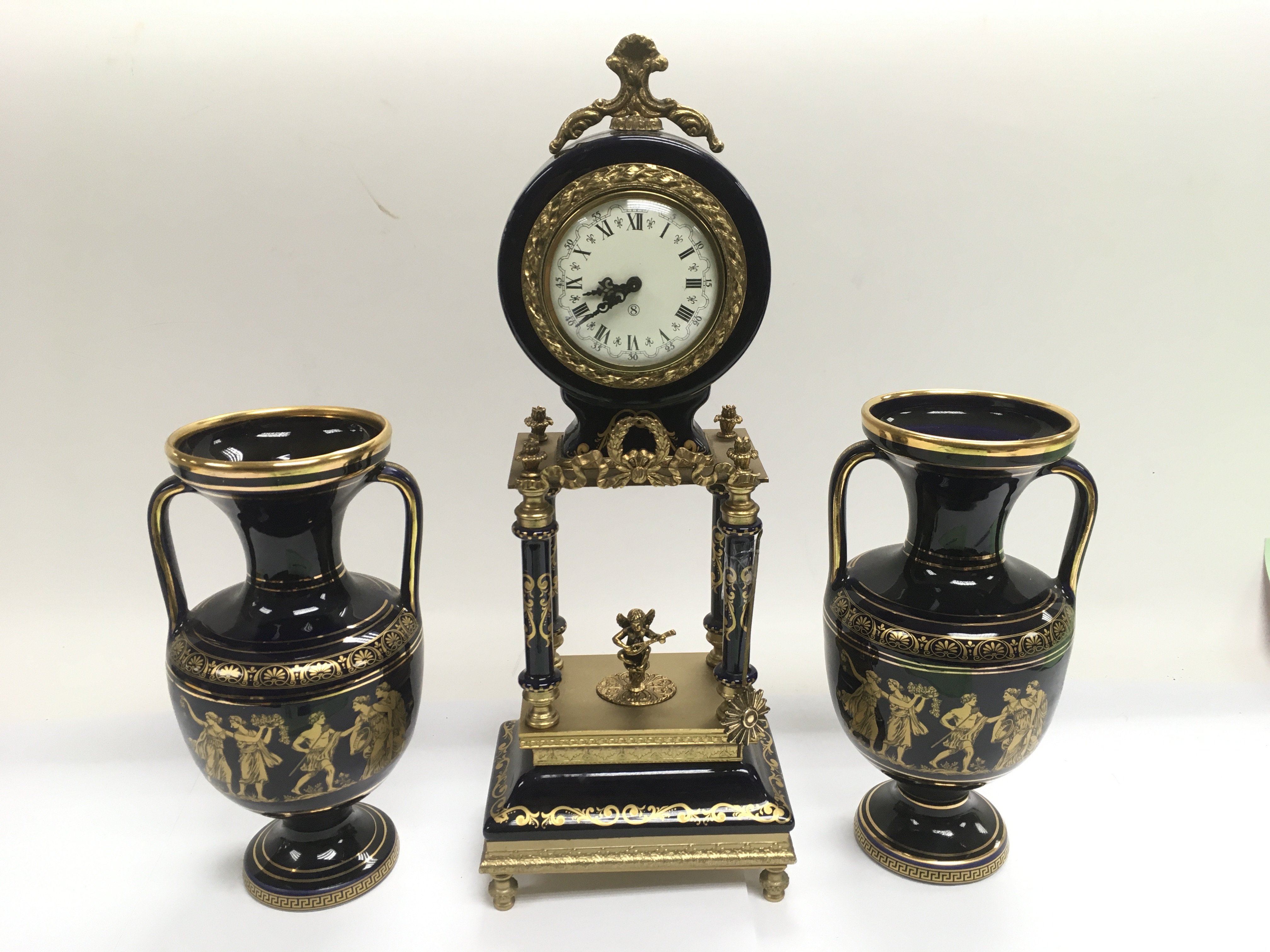 An 8 day porcelain clock garniture in blue and gil