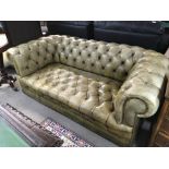 A Green leather upholstered Chesterfield sofa with