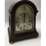 A small arched topped silvered dial mantle clock.