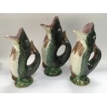 Three graduated Majolica glug jugs, the largest ap