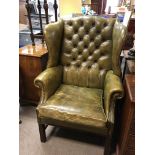 A Green leather and Mahogany wing arm chair with b