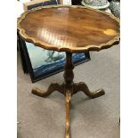 A Yew wood occasional table with a shaped top on a