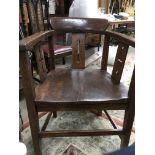 A oak open arm chair with solid seat on square tap