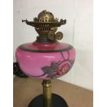 A oil lamp with pink font and cranberry shade .