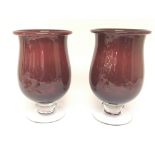 A pair of large deep red glass vases with clear tu