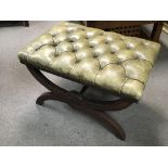 A Green leather upholstered stool with a rectangul