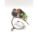 A Swarovski pair of Gouldian Finches perched on a