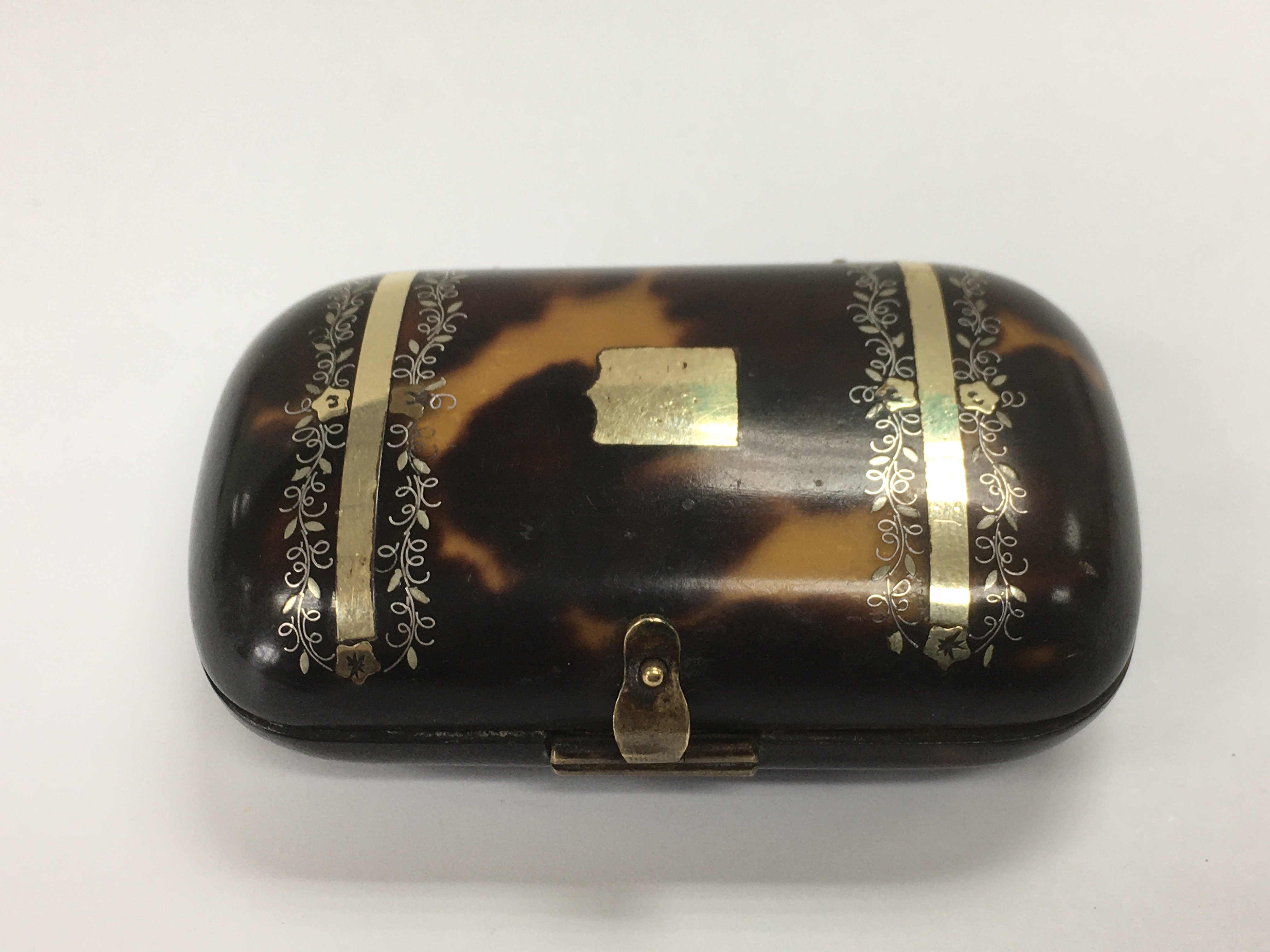 A tortoiseshell box purse inset with yellow metal