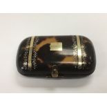 A tortoiseshell box purse inset with yellow metal