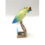 A swarovski parrot on a wooden stand approx 22 cm