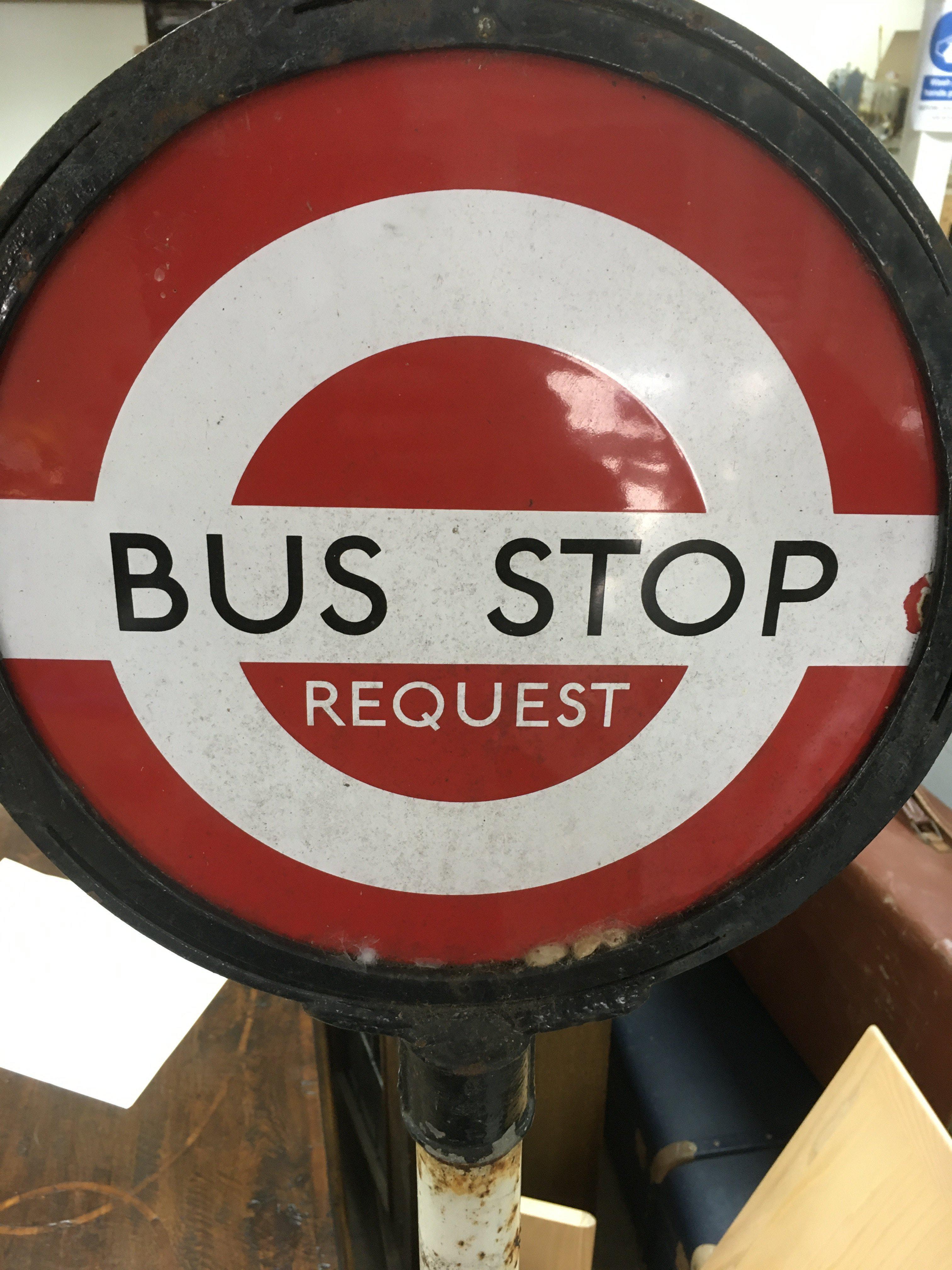 A enamel and cast iron bus stop sign.