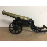 A brass model of a cannon on a cast iron carriage