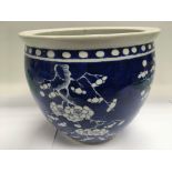 A blue and white fish bowl decorated with prunus b