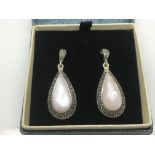 A pair of silver drop earrings set with mother of