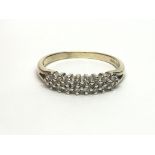 A 9ct gold diamond ring set with three rows of dia