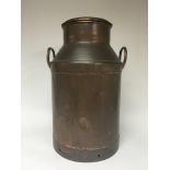 A Vintage copper milk churn with raised handles an