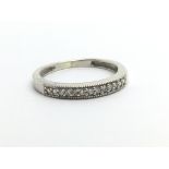 An unmarked white metal half eternity ring, approx