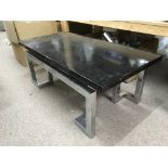 An Art Deco coffee table with chrome legs and a bl