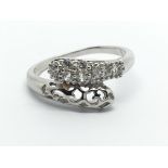 A white gold ring in the form of snakes heads set
