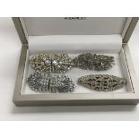 Four dress brooches set with clear stones.