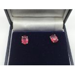 A boxed pair of silver ear studs set with treated