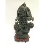 A carved jade ornament of a dragon raised on a har