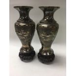 A pair of white metal Chinese vases decorated with