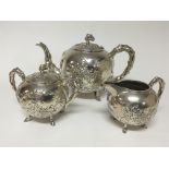A Chinese silver three piece tea set repousse chas