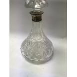 A cut glass decanter with silver collar .