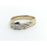 A 9ct gold ring set with three princess cut diamon