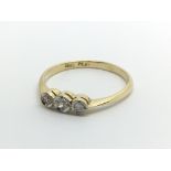 An 18ct gold eing set with three diamonds, approx