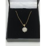 A 9ct gold diamond cluster pendant on a 9ct gold c