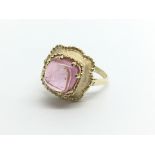 A gold ring set with a pink coloured stone, approx