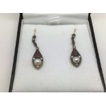 A boxed pair of drop earrings set with rubies, dia