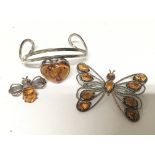 A white metal amber set bracelet a brooch in the f