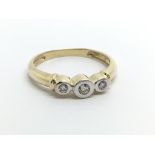 An unmarked yellow metal three stone diamond ring,
