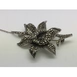 A vintage silver and marcasite flower brooch - NO
