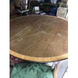 A large circular dining table of Edwardian style t