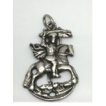An antique silver pendant in the form of St George