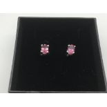 A boxed pair of silver ear studs set with pink tou