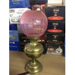 A Victorian style oil lamp with cranberry shade -