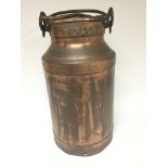 A copper milk churn and lid the rim with name Wing