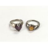 Two silver rings, one set with amber, the other se