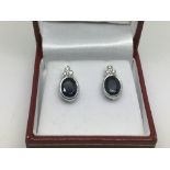 A pair of 18ct white gold earrings set with centra