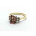 An 18carat gold ring set with a pink Topaz flanked