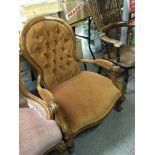 A Victorian style open arm chair with button back