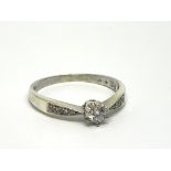 A 9ct white gold solitaire diamond ring with furth