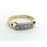 A gold ring inset with a row of five diamonds. Rin